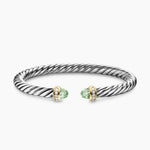 Silver bracelet with green gemstones on a white background featuring both Yellow Gold and Diamond on End Caps.