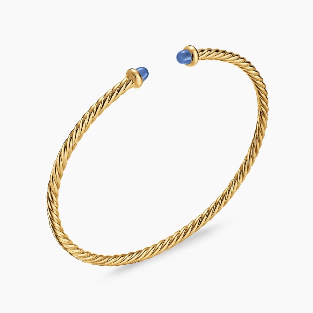 Gold bracelet with blue stones on a white background