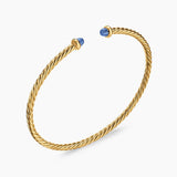 Gold bracelet with blue stones on a white background
