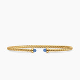 Gold bracelet with blue gemstones on a white background