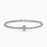 Silver Chain Bracelet with a cross in the center of the piece layed out on a white background.
