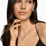 Woman with long brown hair wearing the MINI CUSHION CUT AMULET Sterling Silver with 14K Yellow Gold  boarder and Sky Blue Topaz gemstone in the center.