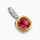 Amulet with red garnet gemstone and gold and silver accents on a white background