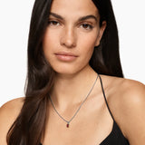 Woman wearing a garnet amulet necklace with a white background