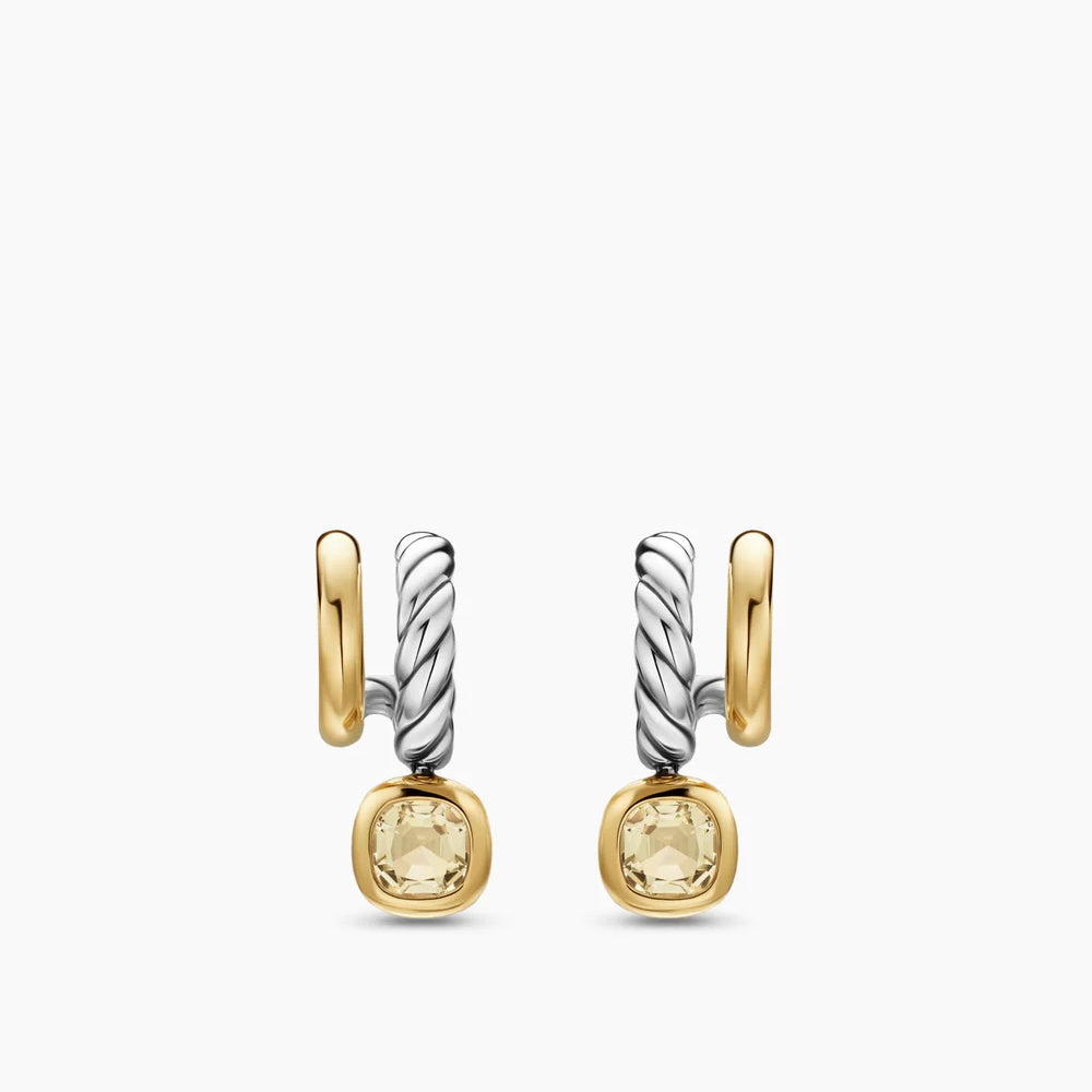 Pair of gold and silver earrings with yellow gemstones on a white background