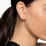 Yellow gold hoop huggie earrings with a smooth polished exterior and a cable texture on the inside of the hoop. 