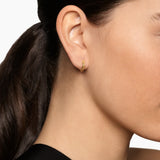 Yellow gold hoop huggie earrings with a smooth polished exterior and a cable texture on the inside of the hoop. 