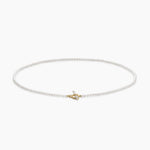 Delicate pearl necklace with a small gold clasp on a white background