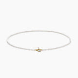 Delicate pearl necklace with a small gold clasp on a white background