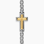 Up close image showing a gold cross pendant fixed onto a silver box chain