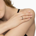 Up close of a woman wearing a Sterling silver cable loop ring with a gold accent in the middle on her ring finger 