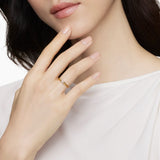 Woman wearing a gold cable band ring with a diamond x  in the center 
