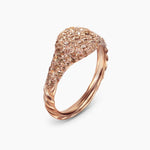Rose gold ring with pave diamonds with a textured cable band on a white  background